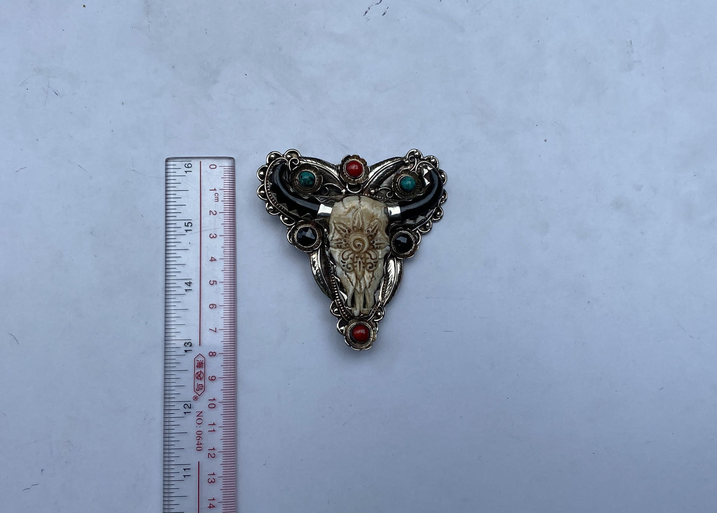 Bulls head shaped Tibetan Silver Belt Buckle adorned with Natural Turquoise, Red Coral, Black Onyx. Floral Design carved on buffalo bone.