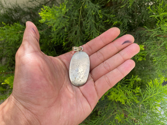 Soul Sentinel: Carved Skull on Tibetan Silver Amulet, Carved Skull Amulet in Tibetan Silver.