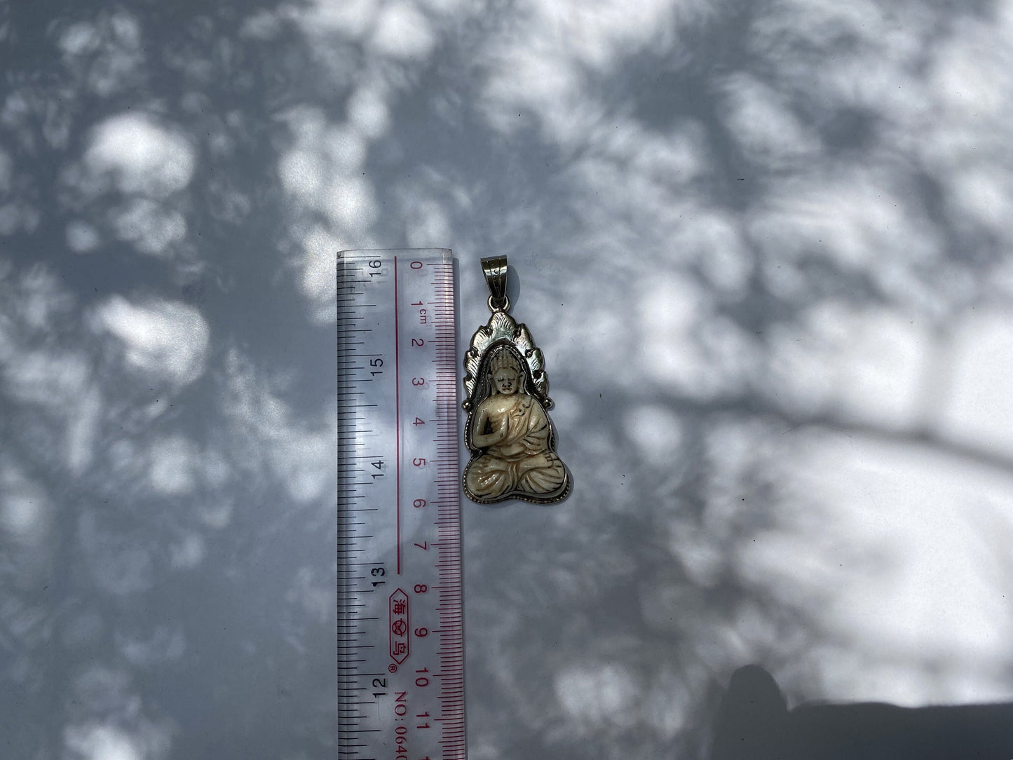 Harmony and Heritage: Buddha on Buffalo Bone with Tibetan Silver Surround, Buddha Carved Buffalo Bone Pendant in Tibetan Silver.