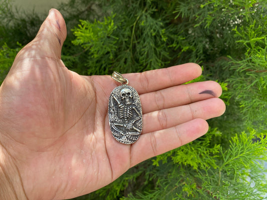 Soul Sentinel: Carved Skull on Tibetan Silver Amulet, Carved Skull Amulet in Tibetan Silver.